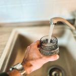 a hand holding a glass of water