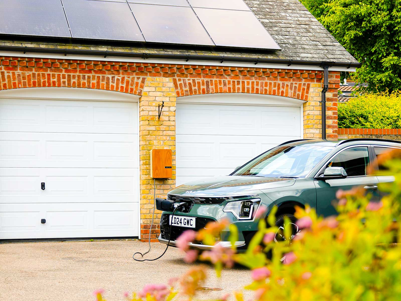 Home with rooftop solar panels and an electric car charger