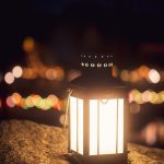 a lit lantern sitting on top of a rock
