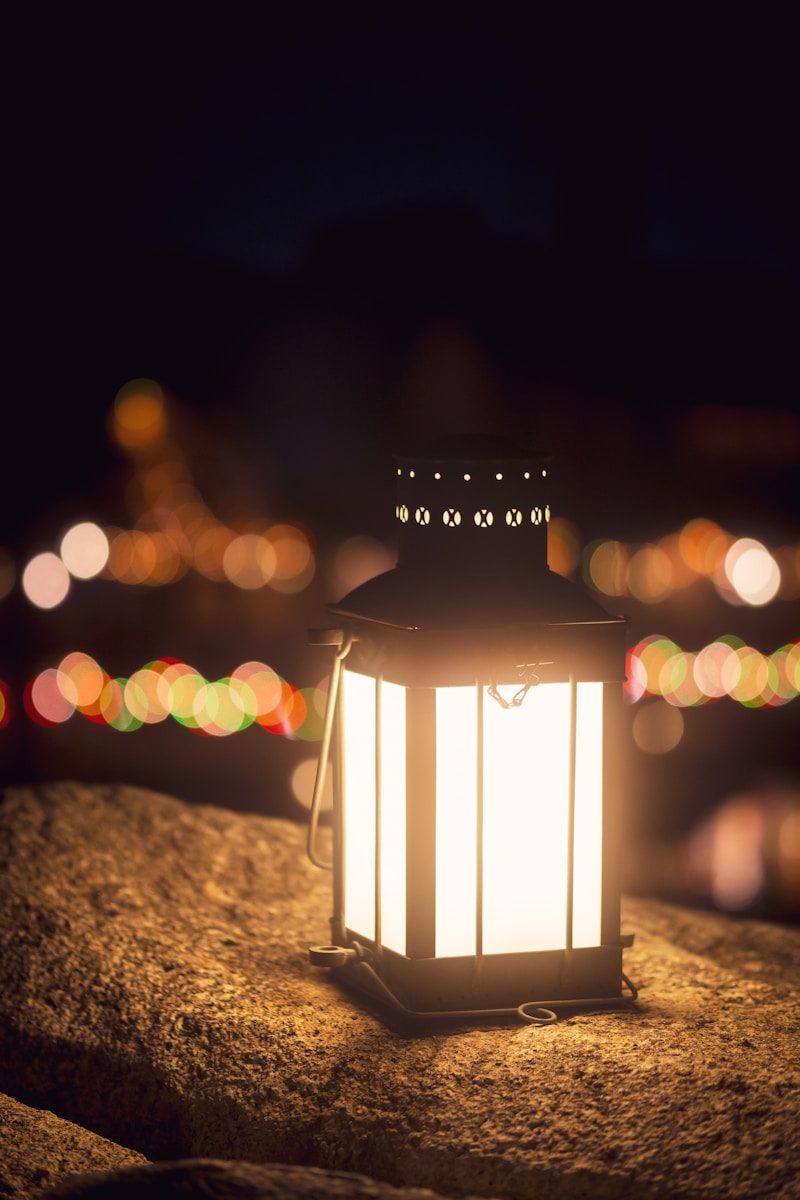 a lit lantern sitting on top of a rock