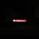 a red emergency sign lit up in the dark